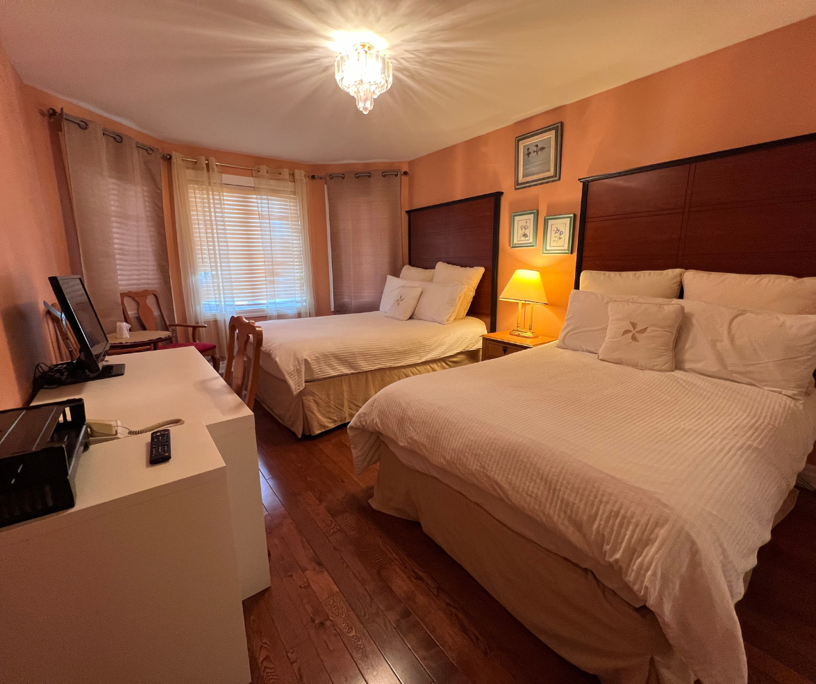 Room with two double beds and hardwood floor